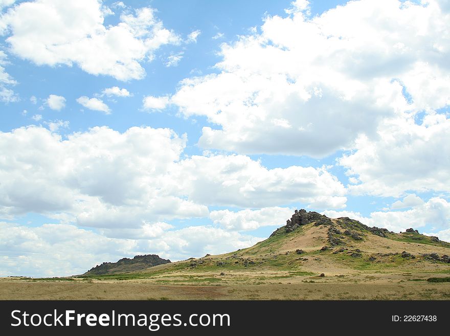 Steppe landscape. hill covered grass. sky with clouds