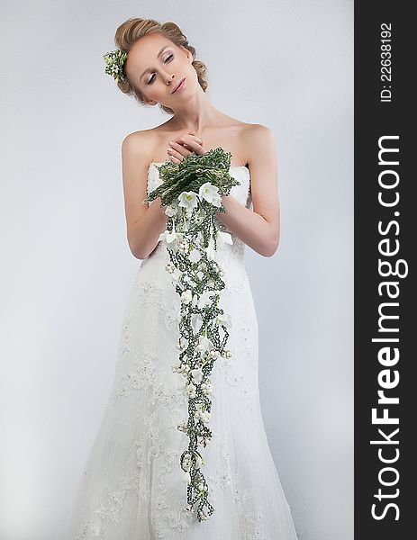 Floristics - attractive female bride blond hair model with floral bouquet of fresh tender flowers - series of photos. Floristics - attractive female bride blond hair model with floral bouquet of fresh tender flowers - series of photos