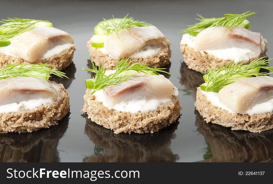 Sandwiches with herring, cucumber and dill