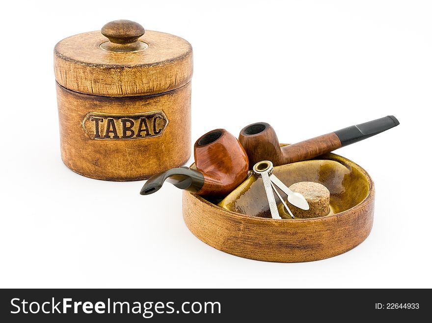 Two pipes and tobacco tin on white background. Two pipes and tobacco tin on white background