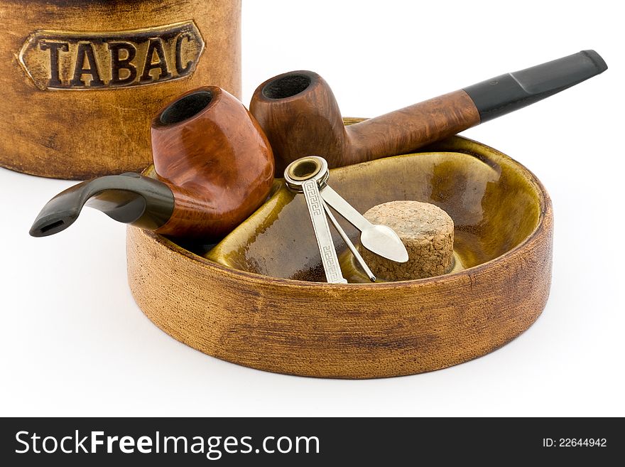 Two pipes and tobacco tin on white background. Two pipes and tobacco tin on white background