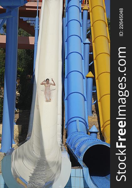 Tenage girl on white water slide, accelerating. Tenage girl on white water slide, accelerating