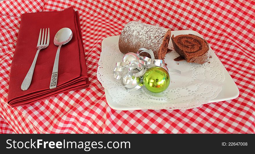 This photo shows a plated Chocolate Log complete with Napkin and Cutlery. This photo shows a plated Chocolate Log complete with Napkin and Cutlery