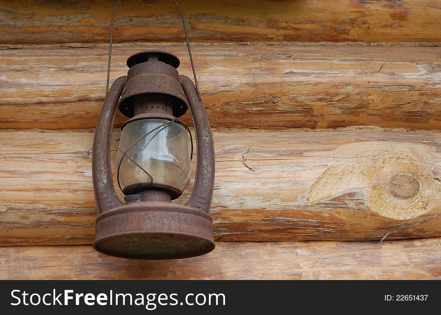 Old rusty kerosene lamp on the wooden wall. Old rusty kerosene lamp on the wooden wall