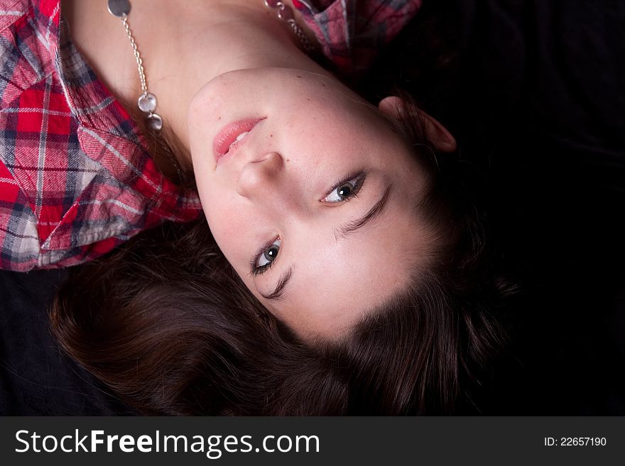 Teen female in pladi shirt laying down. Teen female in pladi shirt laying down