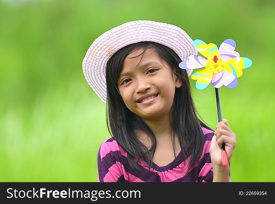 A young happy girl posing with a toy on green environmant background. A young happy girl posing with a toy on green environmant background