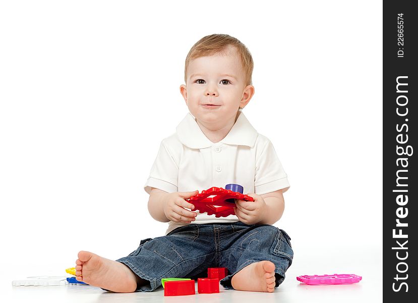 Cute little child is playing with toys while sitting on floor. Cute little child is playing with toys while sitting on floor