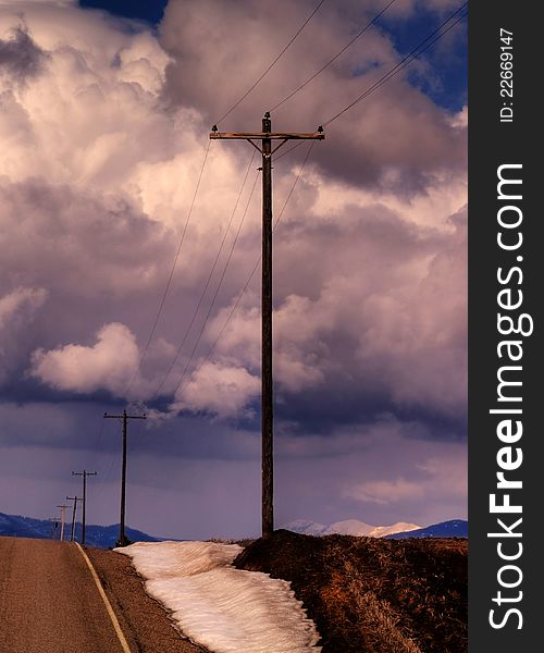 This image of the rural road flanked with snow banks and telephone poles was taken during late winter in NW Montana as a snow squall approached. This image of the rural road flanked with snow banks and telephone poles was taken during late winter in NW Montana as a snow squall approached.