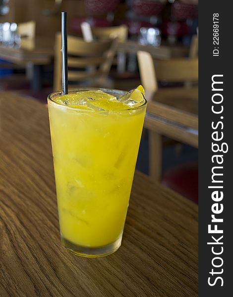 Pineapple with ice and vodka in a tetrahedral glass with black straw. Pineapple with ice and vodka in a tetrahedral glass with black straw