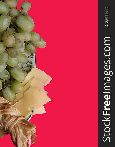 Cluster of white grapes, smoked cheese and Dutch cheese on a red background. Cluster of white grapes, smoked cheese and Dutch cheese on a red background