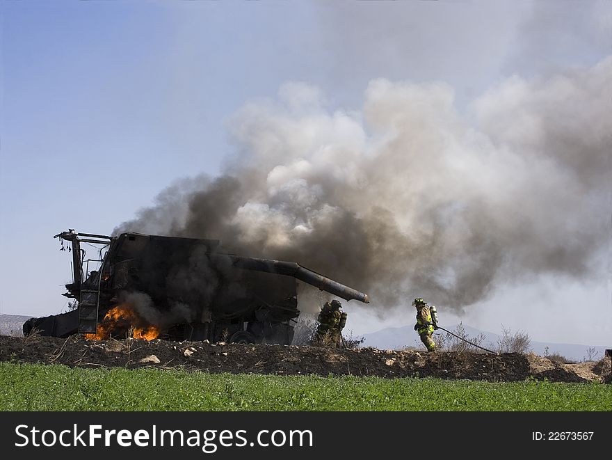 Firefighters put out burning tractor in the countryside
