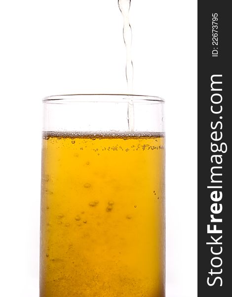 Shot of pouring yellow beer in to a tall glass. Shot of pouring yellow beer in to a tall glass.