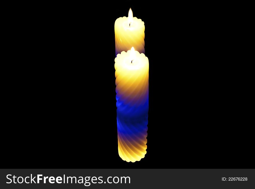 Colored candle on a black background. double reflection. Colored candle on a black background. double reflection