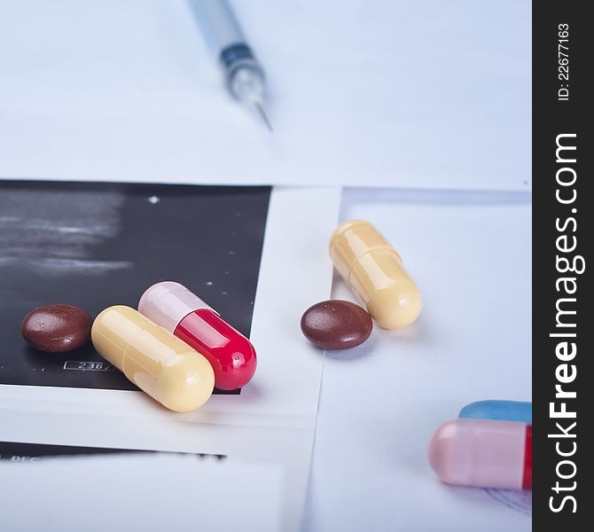 Color pills and capsules on doctors table