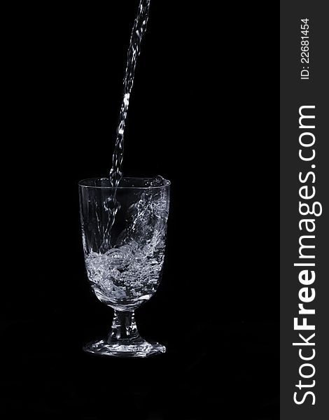 With water splash and transparent glass, on black background. With water splash and transparent glass, on black background.