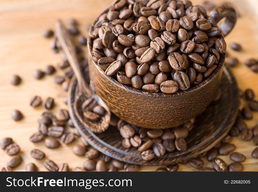 Coffee beans in a wooden cup and saucer