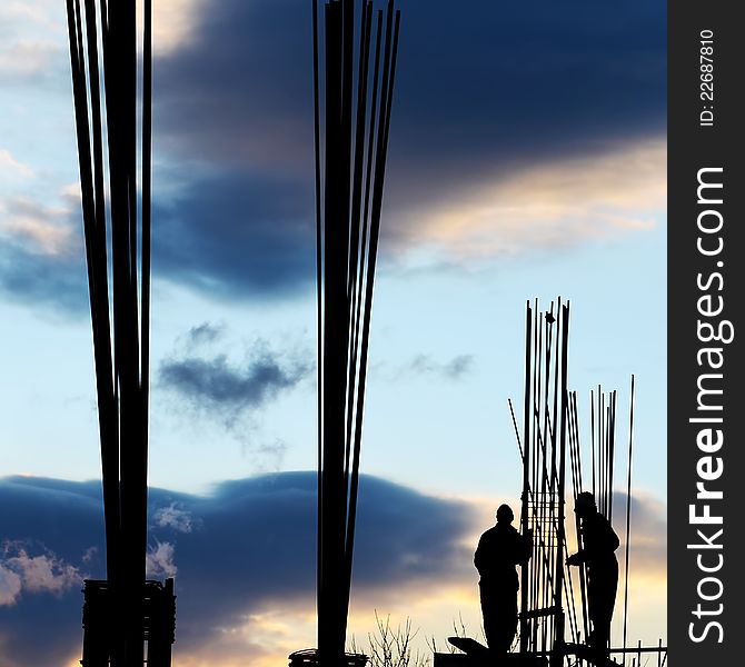 Silhouette of workers and unfinished building. Silhouette of workers and unfinished building