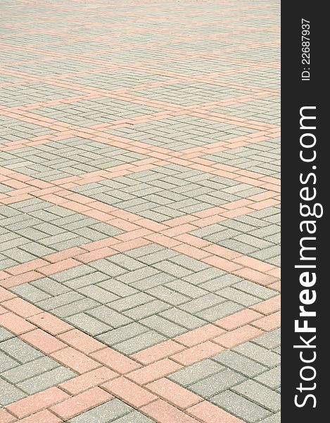 A tiled gray and pink pavement as a background. A tiled gray and pink pavement as a background