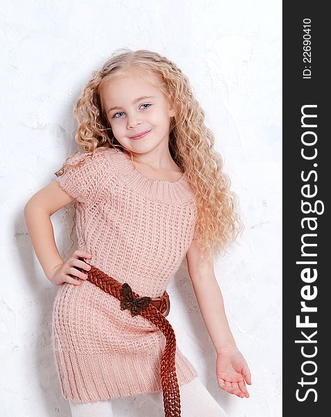 Portrait of adorable blonde little girl posing in fashion knitted dress. Portrait of adorable blonde little girl posing in fashion knitted dress