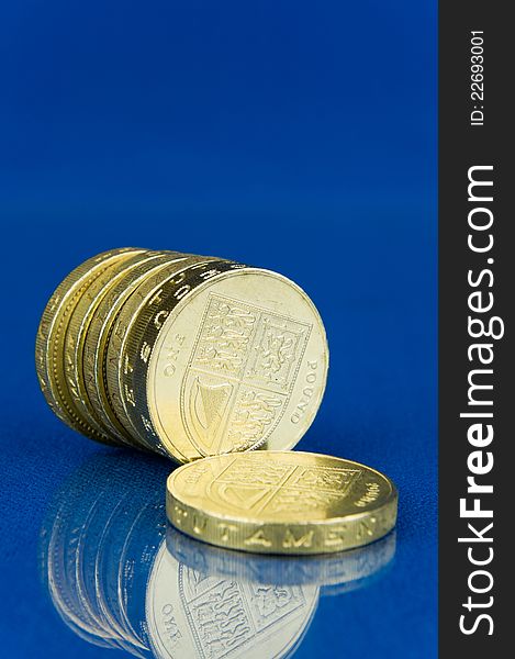 Row of coins with reflection  on blue background. Row of coins with reflection  on blue background