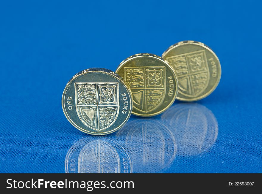 Row of coins with reflection on blue background. Row of coins with reflection on blue background