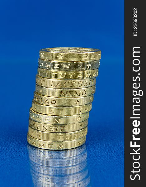 Pile of coins on blue background with reflection. Pile of coins on blue background with reflection