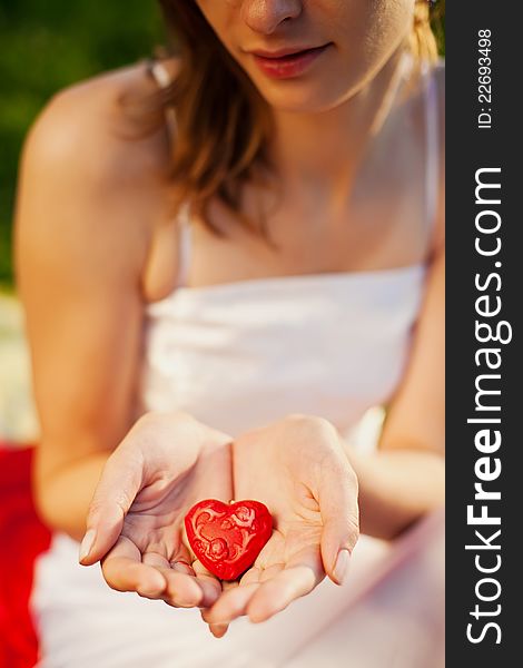 Woman holding red heart in her hands - symbol of love. Woman holding red heart in her hands - symbol of love