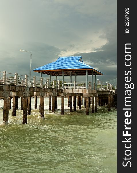 Pier on piles against overcast sky