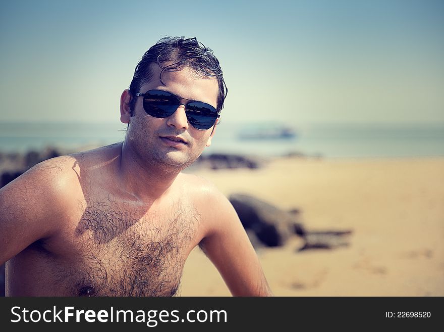 Indian Happy young man getting out of the water with sunglasses. Indian Happy young man getting out of the water with sunglasses