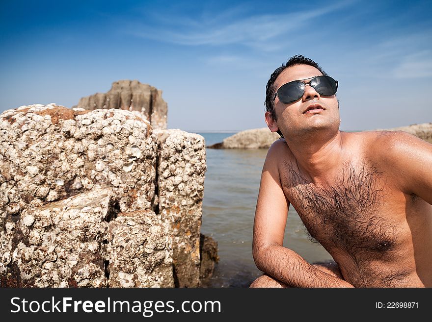 Indian Happy young man getting out of the water with sunglasses. Indian Happy young man getting out of the water with sunglasses