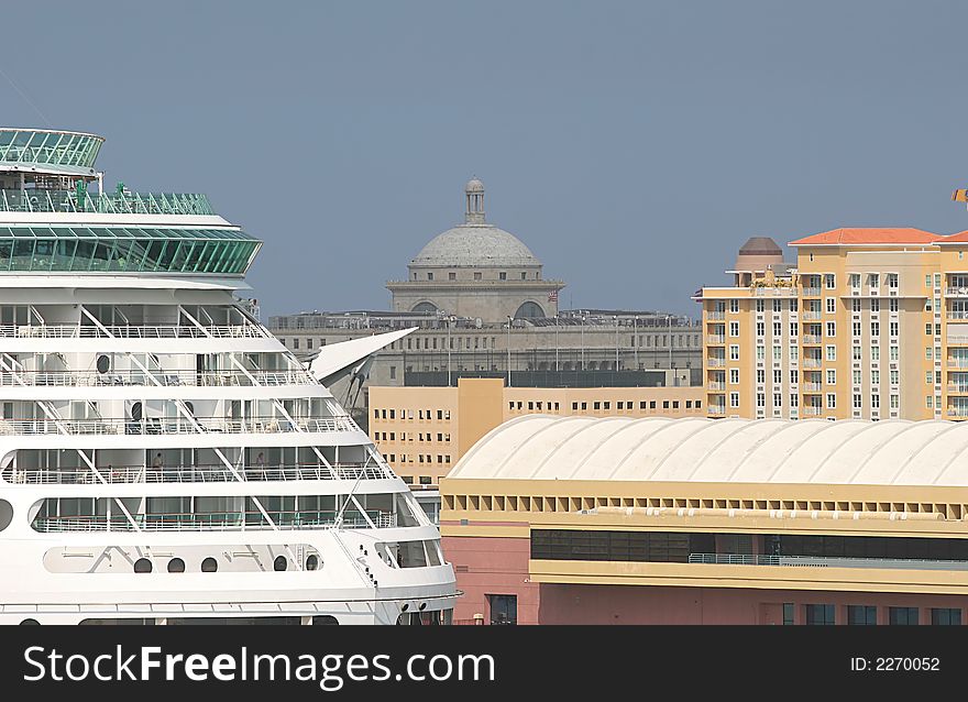 A cruise ship docked in a busy port city. A cruise ship docked in a busy port city