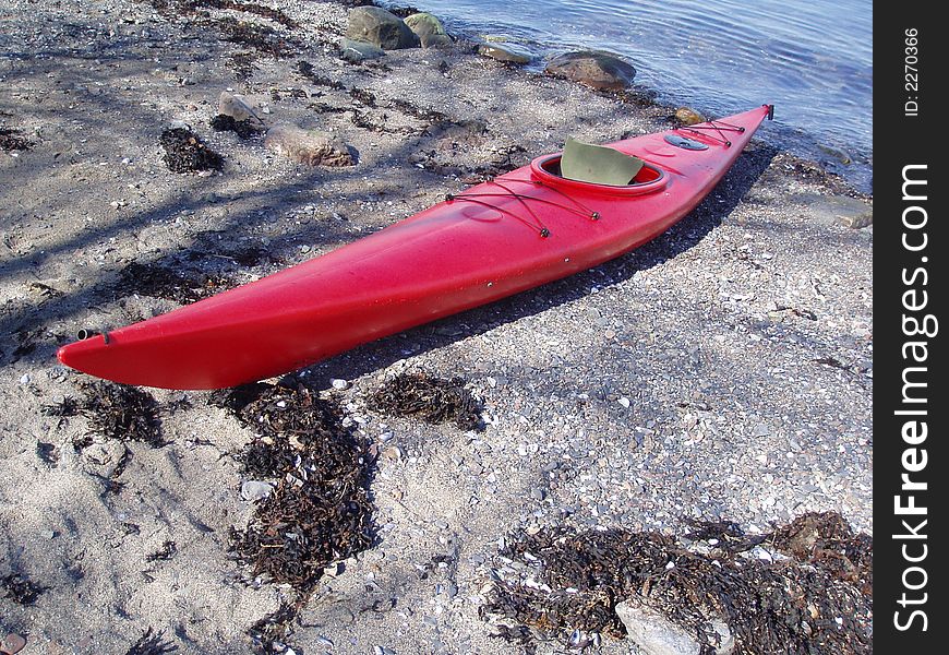 A red canoe on shore by Oslo Fjord,  Norway