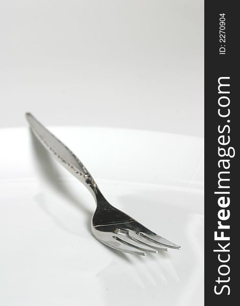 Fork isolated on white plate. Fork isolated on white plate