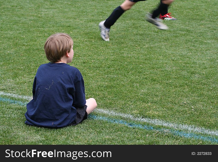 Soccer player watching game from sideline. Soccer player watching game from sideline