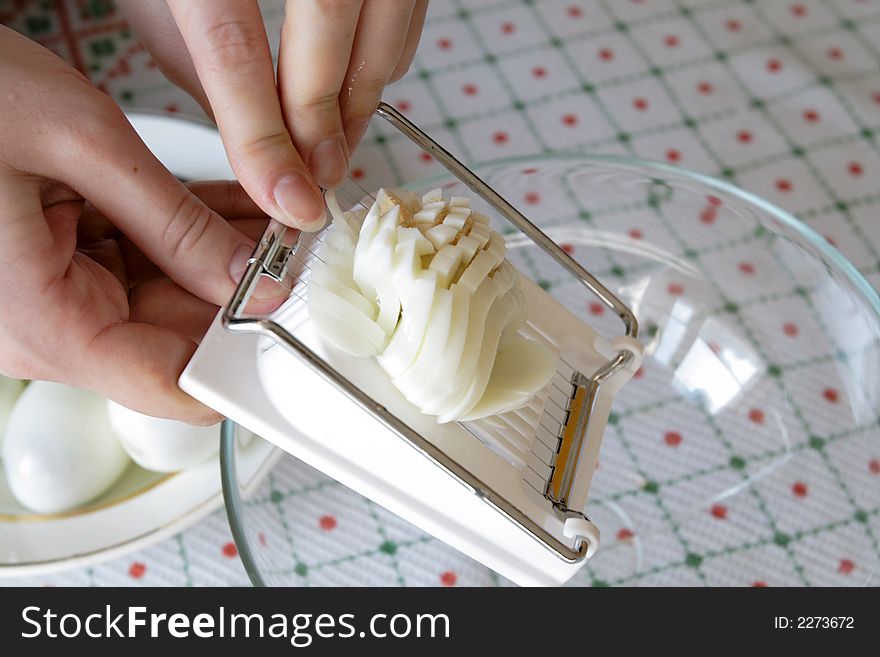 Preparation of boiled eggs for salad by means of the slicer. Preparation of boiled eggs for salad by means of the slicer