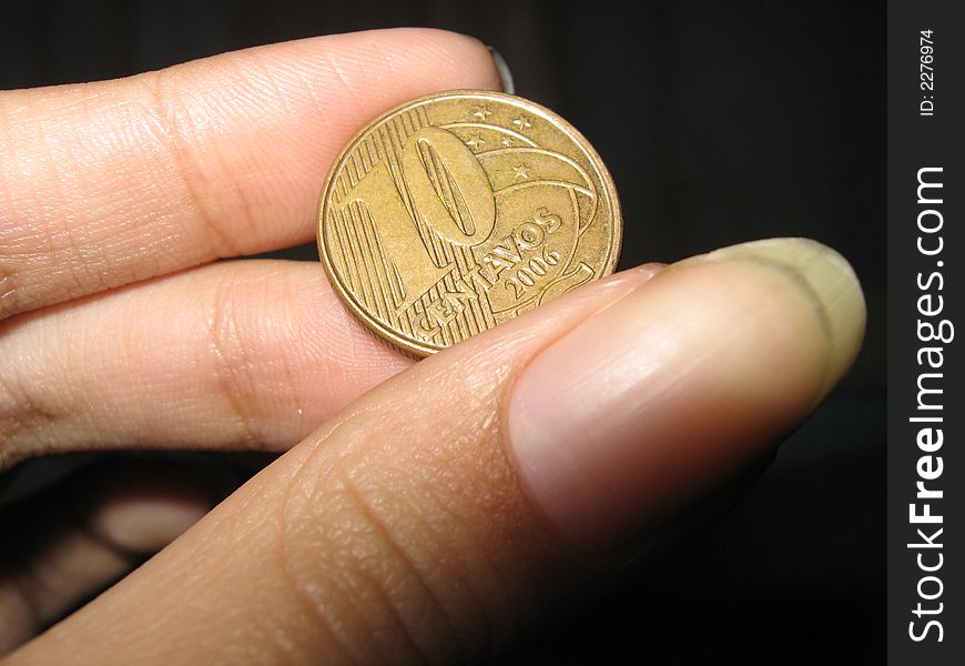 Macro af a Brazilian coin in a Female hand. Macro af a Brazilian coin in a Female hand