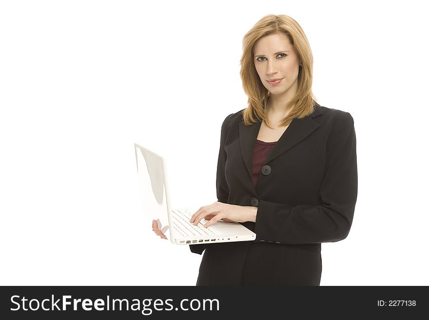 A businesswoman in a suit holds up a laptop. A businesswoman in a suit holds up a laptop