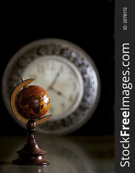 Miniature globe with clock in background