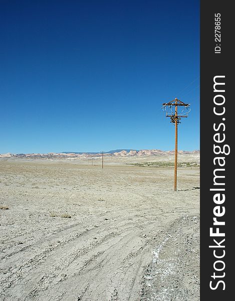 A power line stretches across the vast and seemingly unpopulated desert of southern Utah.