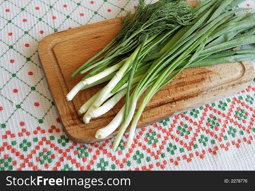 Leek with droplets of water on a wooden plate