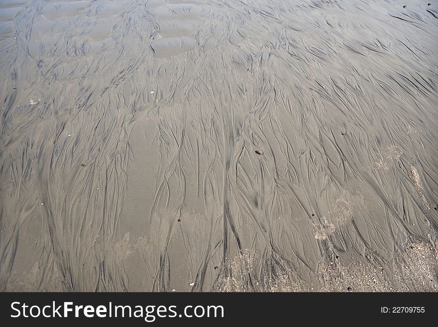 Close up of some wet mud and sand of beach with some water lines. Close up of some wet mud and sand of beach with some water lines