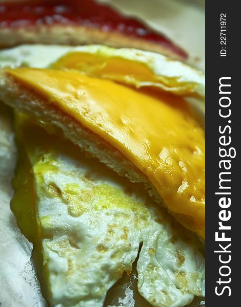 A close up shot of an egg and cheese sandwich spread with grape jelly