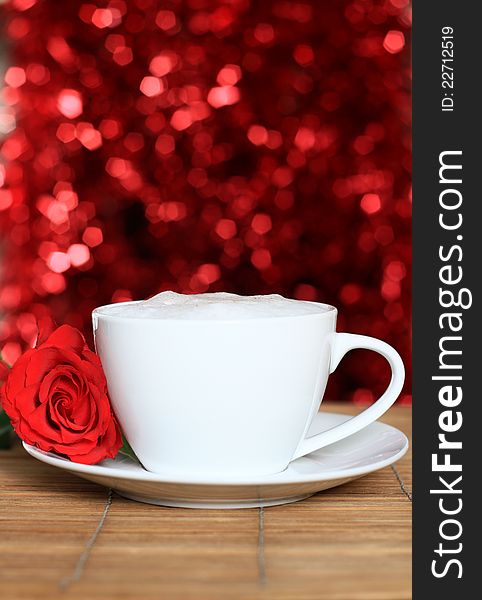 Image of a red rose on valentines day with a cup of coffee