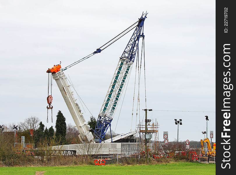 Heavy Duty Crane placing a new Road Bridge over a railway track. Heavy Duty Crane placing a new Road Bridge over a railway track