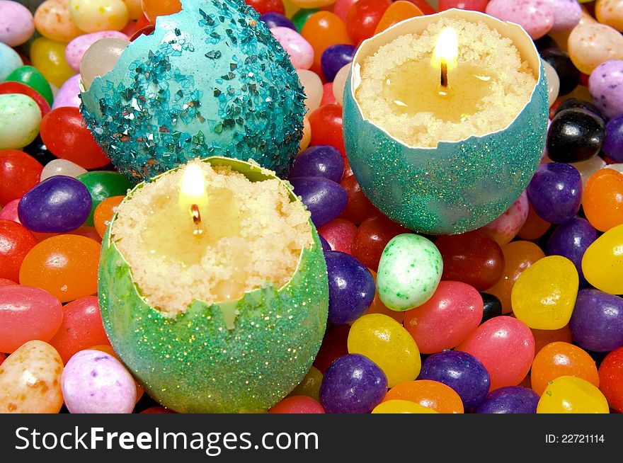 Easter decoration - colorful dyed eggshell candles on a background of candy. Easter decoration - colorful dyed eggshell candles on a background of candy.