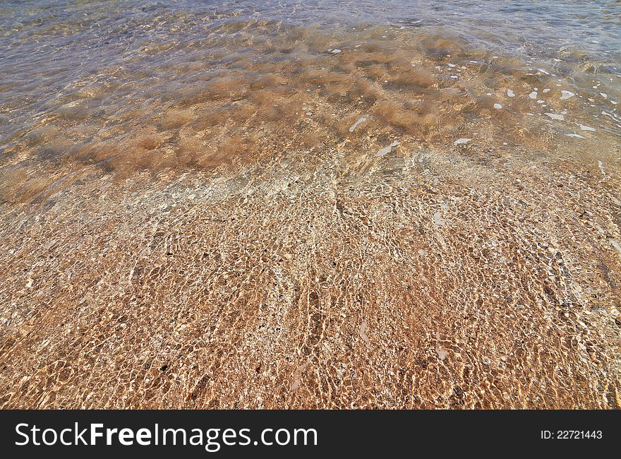 Tranquil sea water motion on a beach as background