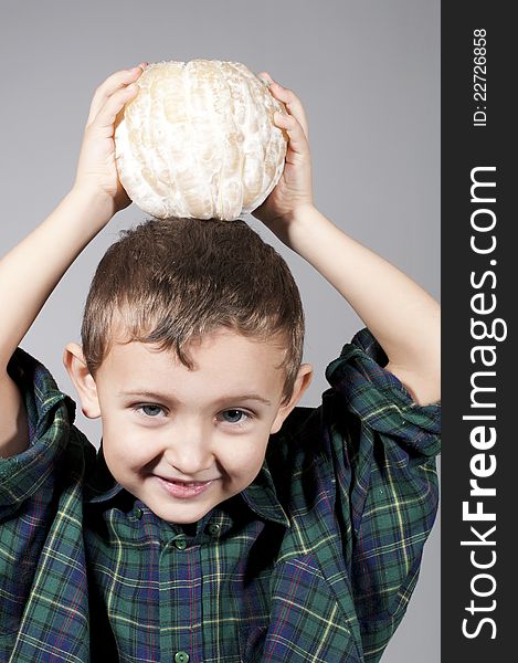 Little boy holding pomelo.