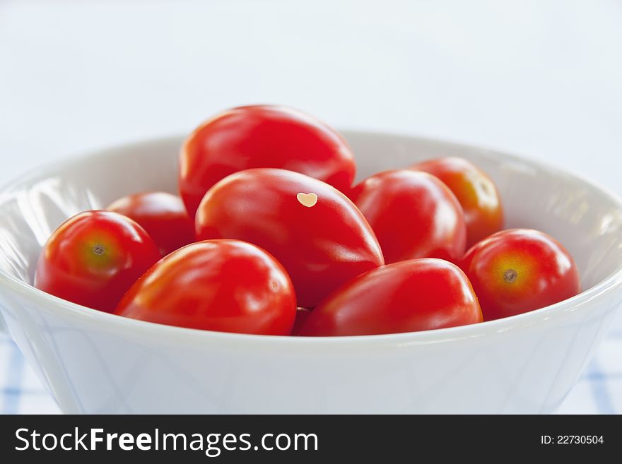 Close-up of fresh tomatoes with small heart in bowl. Close-up of fresh tomatoes with small heart in bowl