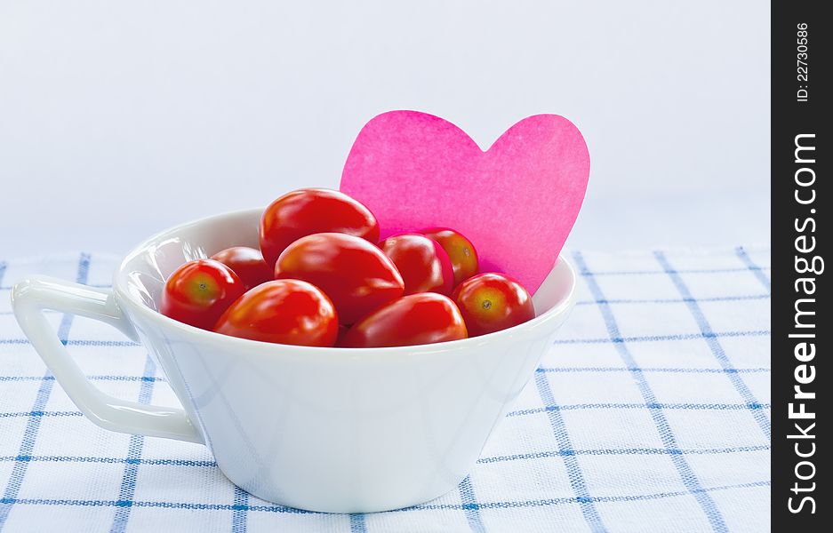 Cup of fresh tomatoes with pink heart
