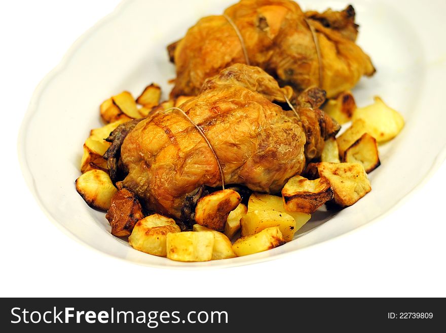 Grilled chicken with roasted potatoes on a white dish